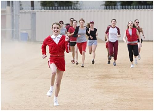 Nancy Drew Emma Roberts u crvenom odijelu koja trči na trkalištu, a slijede suigrači 8 x 10 inča fotografije
